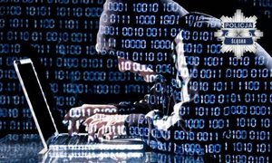 Zdjęcie zamaskowanej osoby siedzącej przy komputerez.