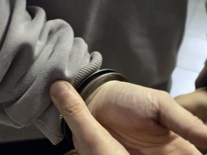 Zdjęcie przedstawiające mężczyznę, który na rękach ma założone kajdanki.