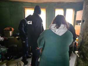 Zdjęcie przedstawiające policjantów, pracownika Ośrodka Pomocy Społecznej oraz mężczyznę.