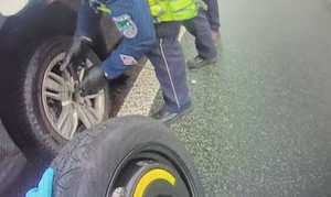 Zdjęcie policjanta wymieniającego opony.