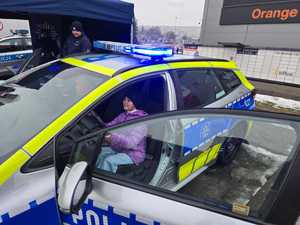 Zdjęcie przedstawiające Policjanta oraz dziecko w radiowozie.