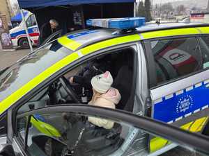 Zdjęcie przedstawiające Policjanta oraz dziecko w radiowozie.