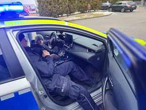 Zdjęcie przedstawiające Policjanta oraz dziecko w radiowozie.