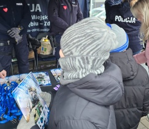 Zdjęcie przedstawiające Policjantów oraz zebranych przy stoisku profilaktycznym.