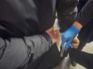 Zdjęcie przedstawiające moment zakładania kajdanek osobie zatrzymanej.