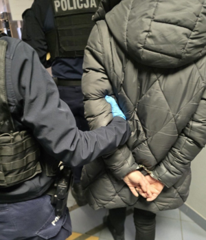 Osoba zatrzymana oraz policjanci.