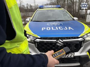 Zdjęcie policjanta trzymającego urządzenie do badania stanu trzeźwości.