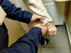 Zdjęcie osoby zatrzymanej oraz moment zakładania kajdanek na ręce.