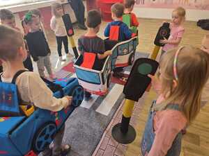 Dzieci bawiące się miasteczkiem ruchu drogowego.