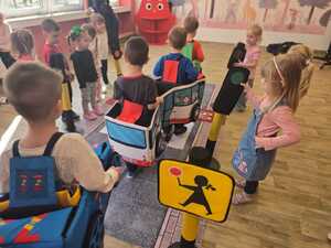 Dzieci bawiące się miasteczkiem ruchu drogowego.