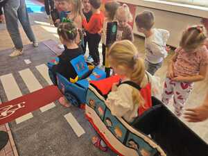 Dzieci bawiące się miasteczkiem ruchu drogowego.