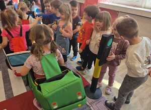 Dzieci bawiące się miasteczkiem ruchu drogowego.