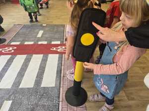 Dzieci bawiące się miasteczkiem ruchu drogowego.