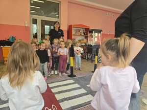 Dzieci bawiące się miasteczkiem ruchu drogowego.