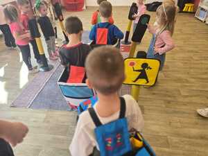 Dzieci bawiące się miasteczkiem ruchu drogowego.