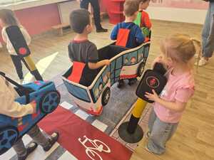 Dzieci bawiące się miasteczkiem ruchu drogowego.