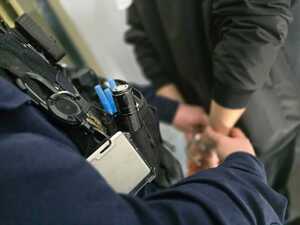 Zatrzymany mężczyzna z założonymi kajdankami.