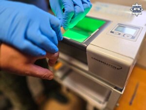 Dłoń osoby zatrzymanej w trakcie pobierania odcisków linii papilarnych.