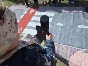 Dzieci bawiące się mobilnym miasteczkiem ruchu drogowego.