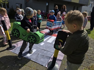 Dzieci bawiące się mobilnym miasteczkiem ruchu drogowego.