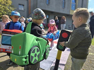 Dzieci bawiące się mobilnym miasteczkiem ruchu drogowego.