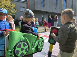 Dzieci bawiące się mobilnym miasteczkiem ruchu drogowego.