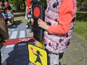 Dzieci bawiące się mobilnym miasteczkiem ruchu drogowego.