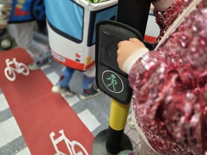 Dzieci bawiące się mobilnym miasteczkiem ruchu drogowego.