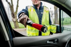 Policjant ruchu drogowego badający stan trzeźwości.