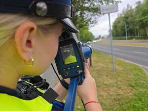 Zdjęcie policjantki dokonującej pomiar prędkości.