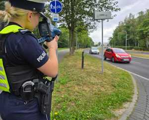 Zdjęcie policjantki dokonującej pomiar prędkości.